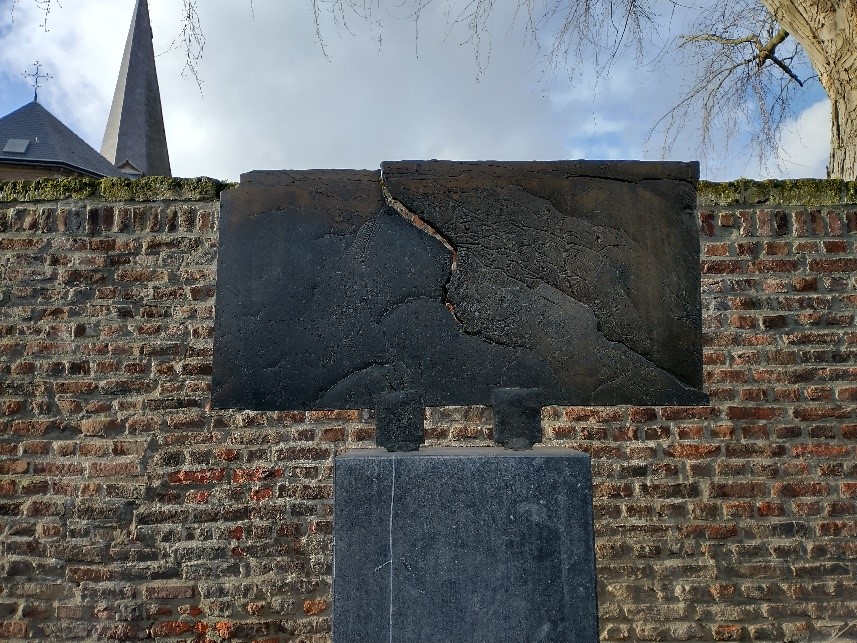  Joods monument aan de Vroenhof in Eijsden is een bronzen plaat op een grijze stenen sokkel met in het midden een breuk